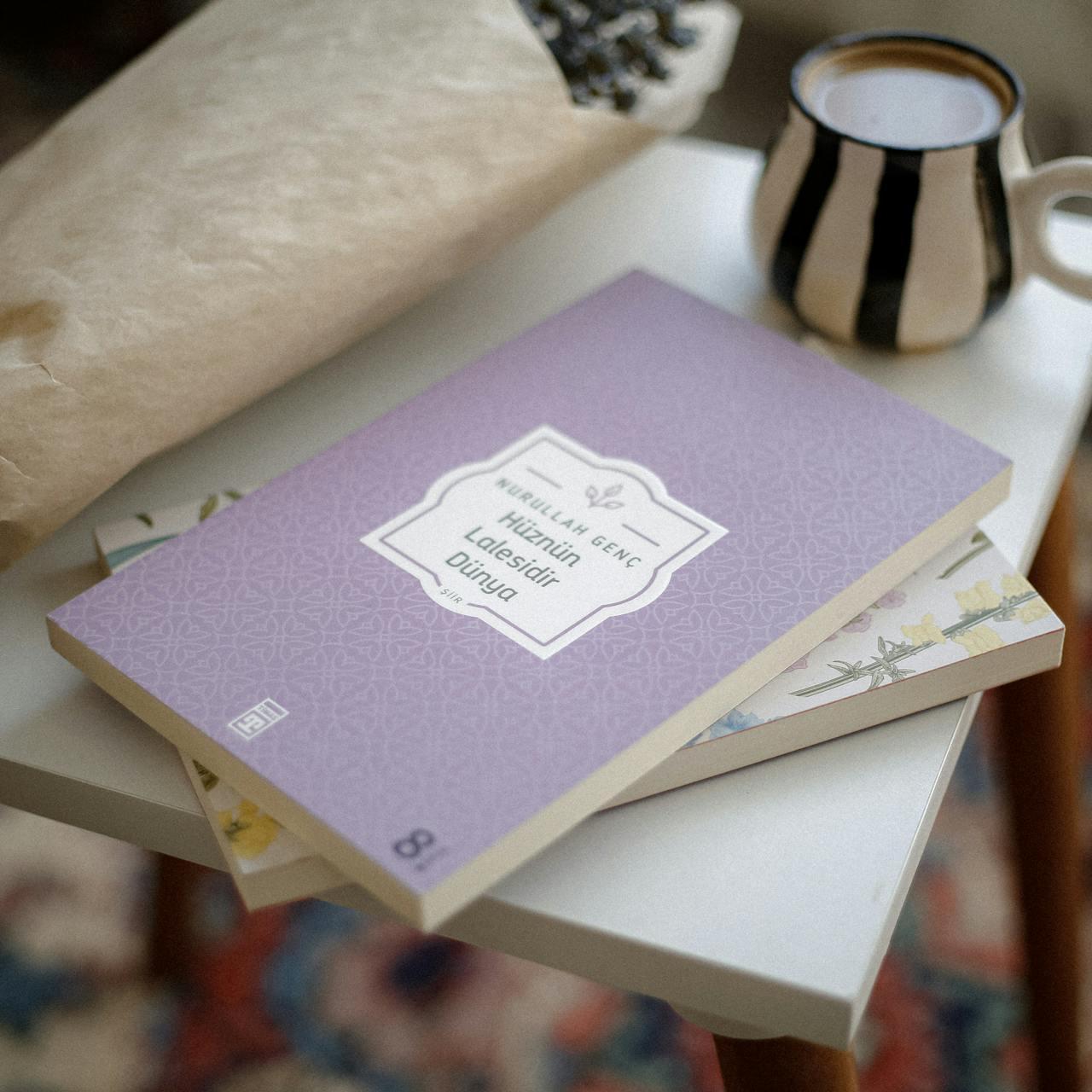home-hero A relaxing setup featuring a coffee mug and books on a white table, perfect for book lovers.